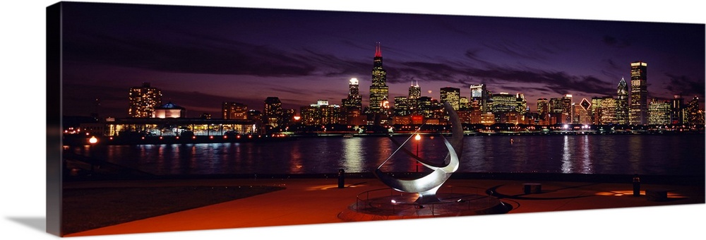 Panoramic photograph of skyline and waterfront at night.
