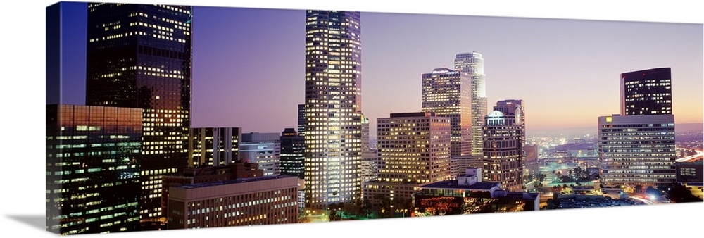 Wide angle photograph on a big canvas of the brightly lit skyline of Los Angeles, California, at sunset.