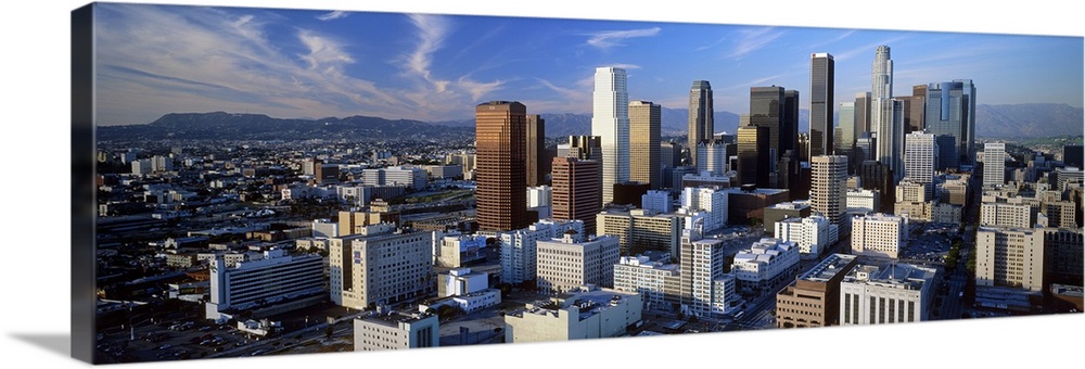 An aerial panoramic photograph taken of downtown Los Angeles as the sun sets and hits the sides of the buildings.