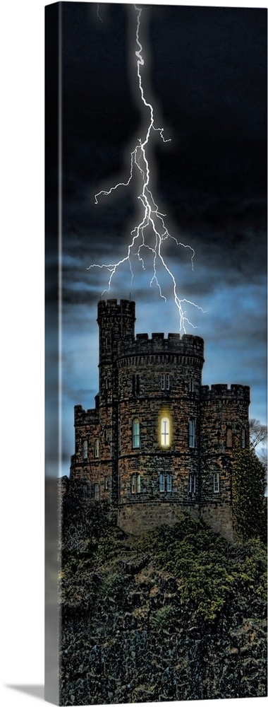 Giant, vertical photograph of lightening striking a castle on a hill, a single light can be seen through one window, on a ...