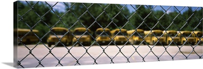Chain-link fence with school buses in the background, Massachusetts