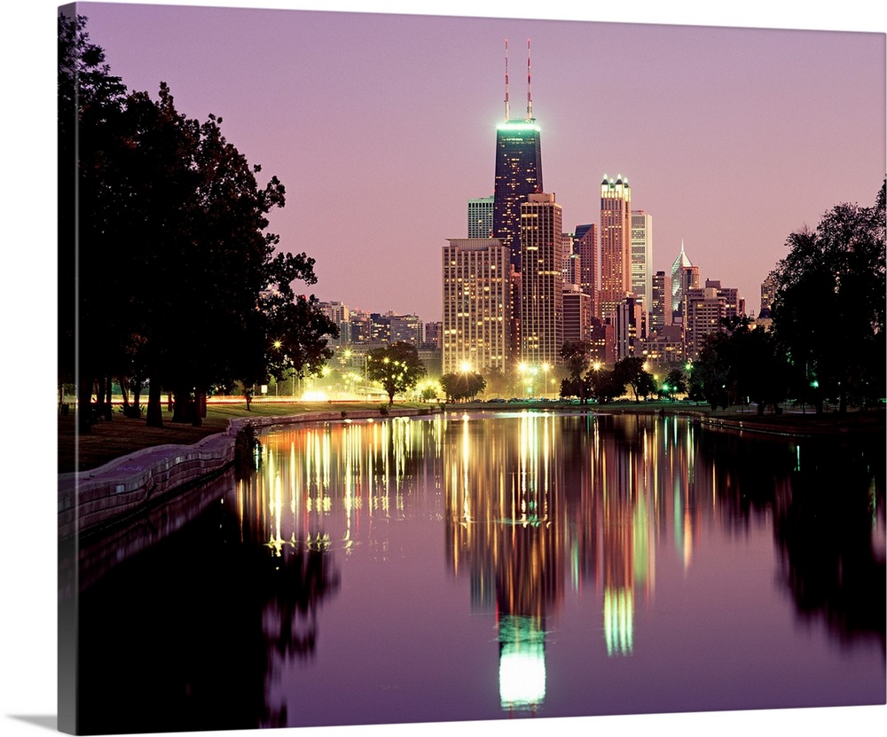 Oversized photograph wall art of city lights and skyscrapers reflecting in a pond in a park.