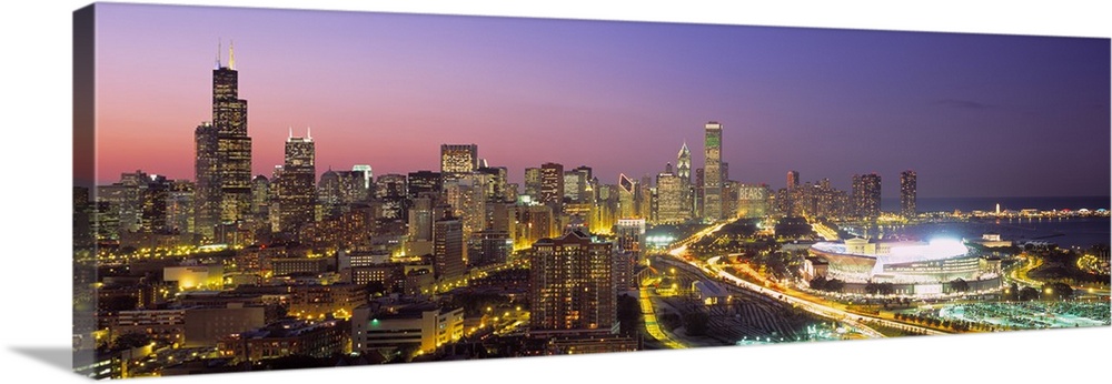 Panoramic photograph captures the intensely bright lights of the busy streets and skyscrapers that fill the skyline of Chi...