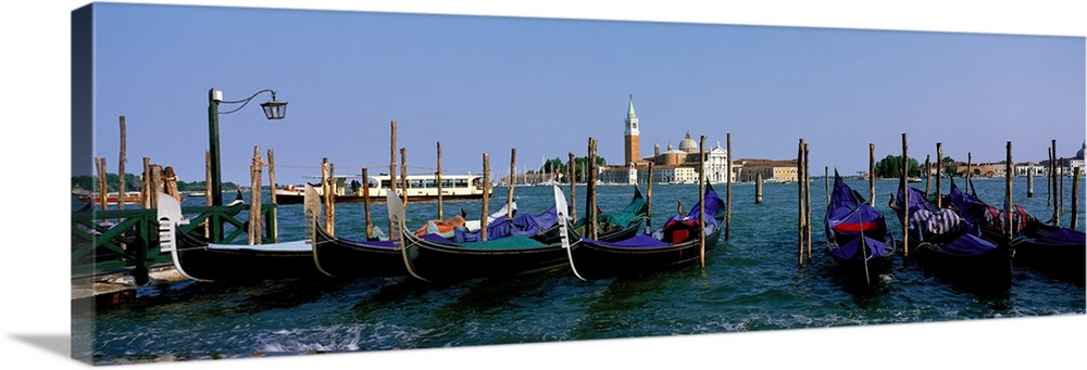 Long photo on canvas of gondolas parked  near posts in Italy.
