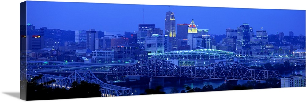 Panoramic photograph of downtown  Cincinnati skyline at night and bridges over the Ohio River.