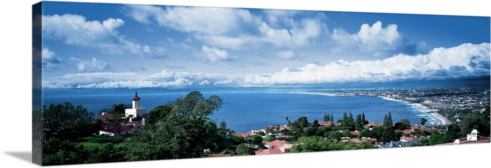 Large panoramic print of a city along the Pacific Ocean with big billowing clouds in the distance.