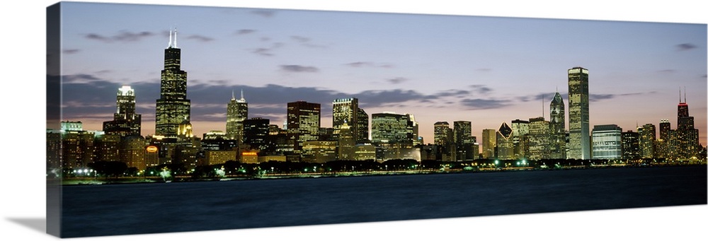 Panoramic photograph displays a horizon filled with tall skyscrapers and buildings as the sun begins to set on the largest...
