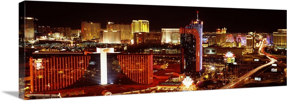 Horizontal photograph on a big canvas of Las Vegas, Nevada, brightly lit at night.