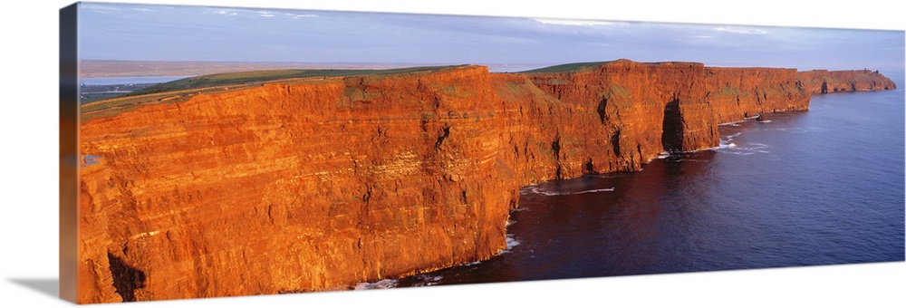 Orange-red cliffside of the Cliffs of Moher County in Clare, Ireland.