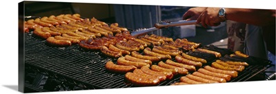 Close-up of a mans hand cooking hot dogs on a barbecue grill, Taste of Chicago, Chicago, Illinois