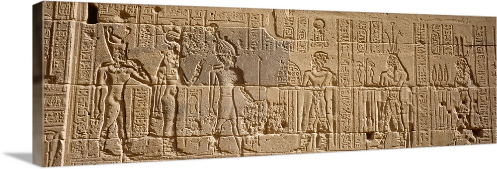 Wide photo on canvas of Egyptian hieroglyphics carved into a rock wall.