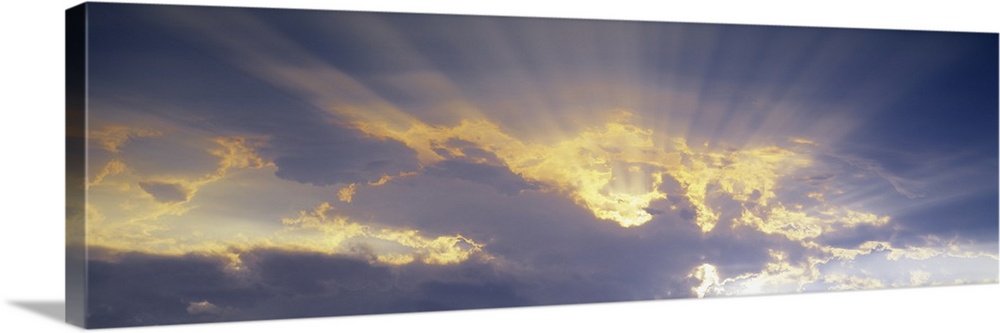 A horizontal canvas photo of sun rays shining through clouds.