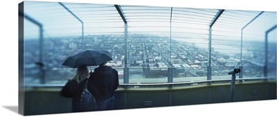 Couple viewing a city from the Space Needle Queen Anne Hill Seattle Washington State
