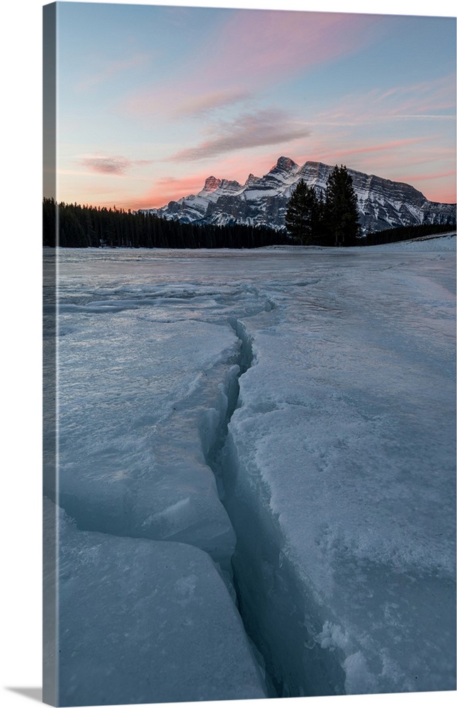 Cracks in ice on frozen lake at sunrise, Mount Rundle, Banff National Park, Alberta, Canada