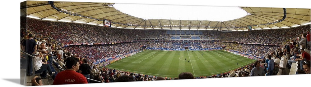 Wide angle photograph of large stadium full of fans, watching a soccer game in Hamburg, Germany.
