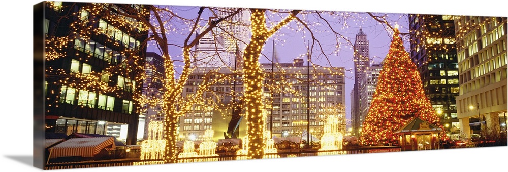 Panoramic photograph of Daley Plaza decked out with Christmas lights in the trees and a large Christmas tree sitting by th...