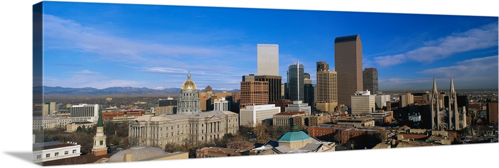 Panoramic photo of a downtown cityscape in Colorado against a bright blue sky.
