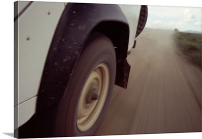 Detail of automobile driving on dirt road, Serengeti National Park, Tanzania.