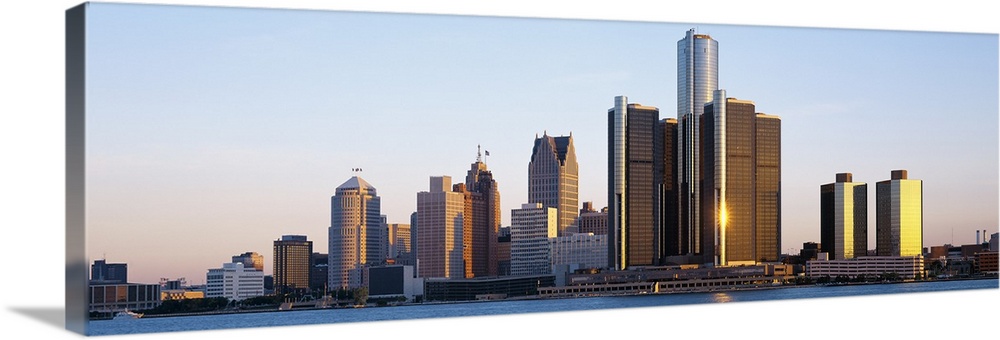Panoramic photograph of city skyline with waterfront.  The sun is reflecting off one of the skyscrapers into the water below.