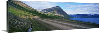 Dirt road along mountain lake, Iceland
