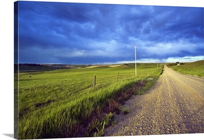 Dirt road through farmland, distant storm clouds, Missouri Breaks, Montana