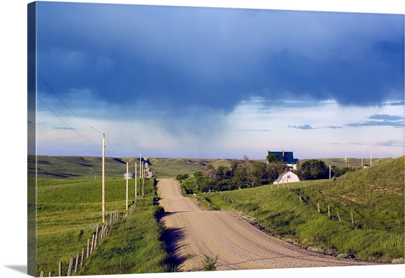 Dirt road through hilly farmland, distant storm, Missouri Breaks
