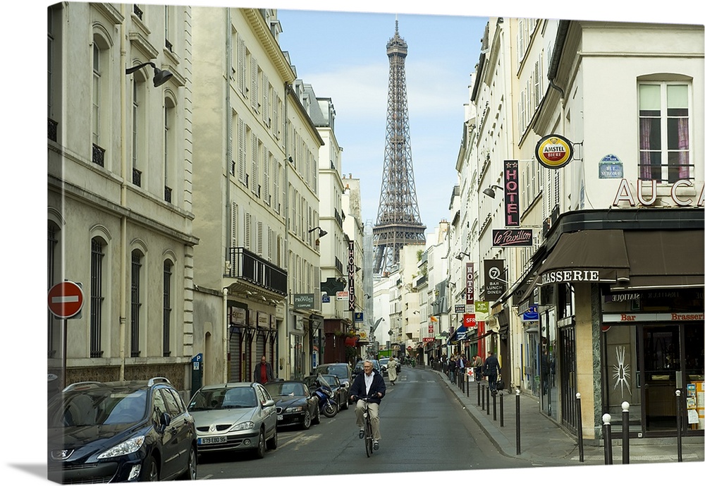 Landscape photograph on an oversized canvas, looking down a street in Paris, full of cars and pedestrians, the Eiffel Towe...