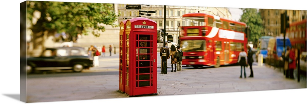 Big horizontal photograph of a red telephone box in Trafalgar Square, London, surrounded by pedestrians and slightly blurr...