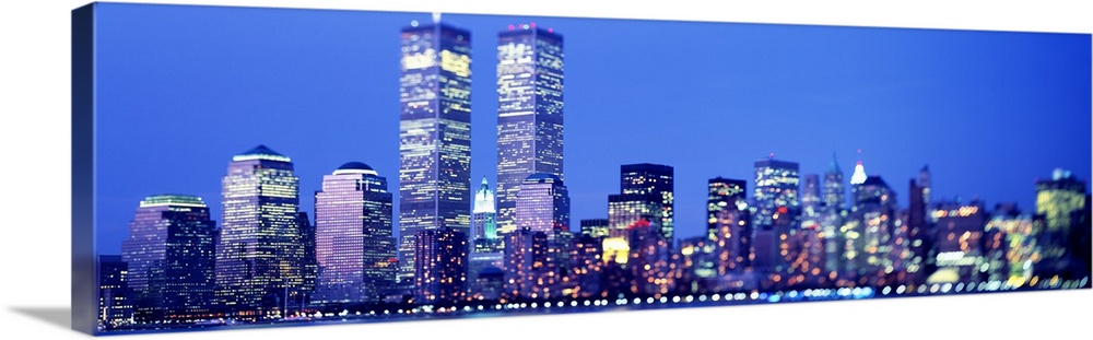 Oversized landscape photograph of the brightly lit skyscrapers of the Manhattan skyline, including the World Trade Center,...