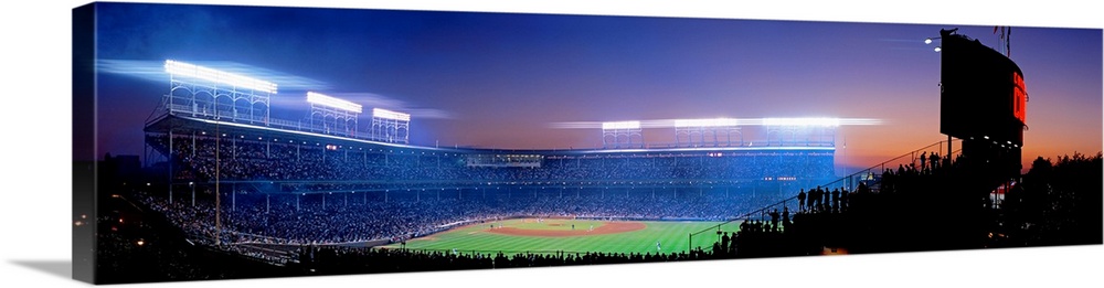 Panoramic photograph of a packed baseball stadium at night.