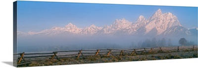 Fence in a field with a mountain range in the background, Grand Teton National Park