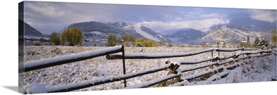 Fence on a snow covered landscape and a chapel in the background, Prince Of Peace Chapel, Aspen, Colorado