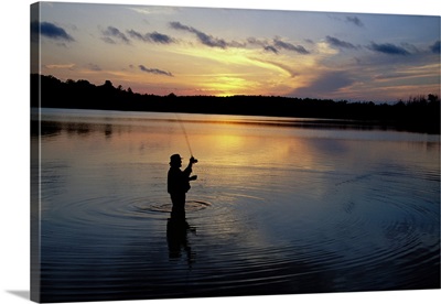 Fly-fisherman silhouetted by sunrise, Mauthe Lake, Kettle Moraine State Forest, Wisconsin
