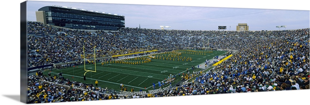 A large panoramic picture taken inside a packed Notre Dame football stadium while the band is playing on the field.