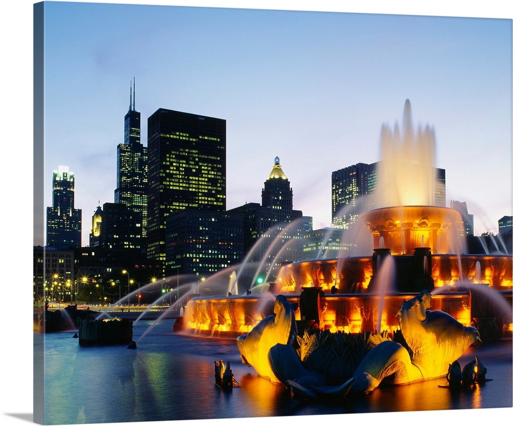Huge photograph taken of Buckingham Fountain lit up at night as it sprays water in an artful sequence.  The background hol...