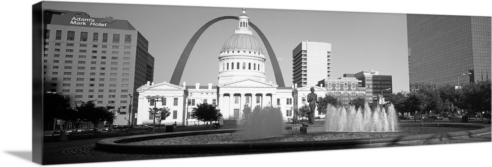 A panoramic view of St. Louis Missouri's capitol building, with the Saint Louis arch in the background and water fountains...