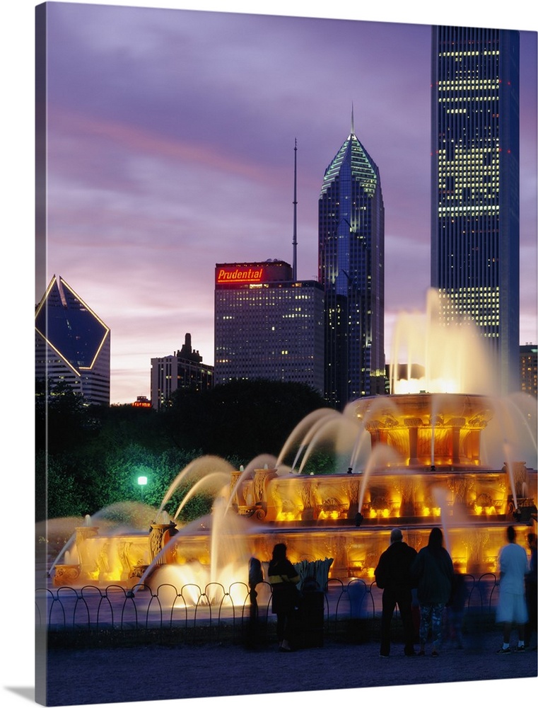 Vertical photograph on a large wall hanging of Buckingham Fountain, lit at night, in Grant Park, Chicago, Illinois.  Skysc...