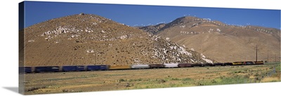 Freight train passing near a mountain range, Tehachapi, California