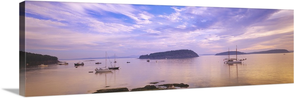 Landscape photograph of numerous small boats in Frenchman Bay beneath a vibrant sky of wispy clouds in Bar Harbor, Maine.