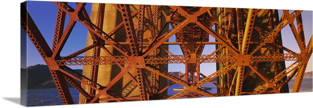 Part of the Golden Gate bridge structure from below is photographed in wide angle view.