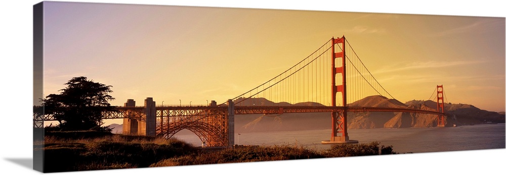 Giant horizontal photograph of San Francisco Bay's suspension bridge, the Golden Gate Bridge, at sunrise.