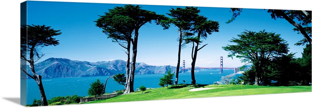 Big panoramic photograph of a seaside golf course in San Francisco, California (CA) with mountains and the Golden Gate Bri...