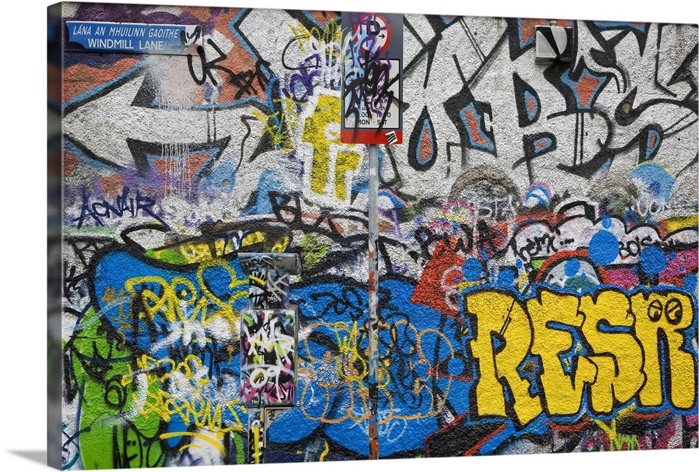 Large photograph of colorful grafitti on the U2 Wall on Windmill Lane in Dublin, Ireland. Crowded mix and clash of cool an...