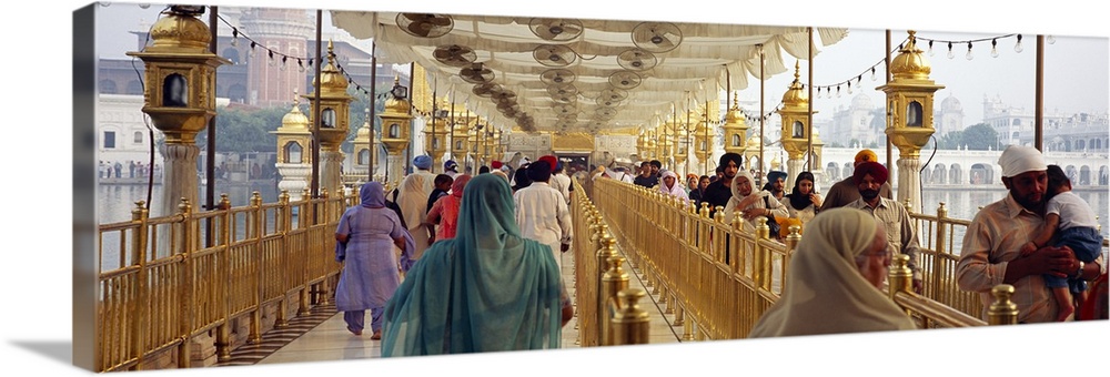 Group of people walking on a bridge over a pond Golden Temple Amritsar Punjab India