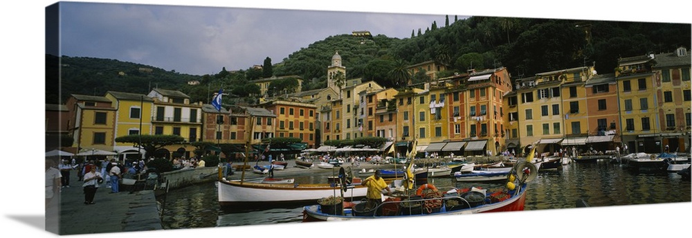 Panoramic canvas of an Italian boat harbor with a bunch of boats and buildings meeting the water in the background.