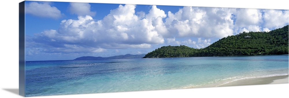Panoramic photo on canvas of a clear ocean meeting a shore with rolling hills on the right side.
