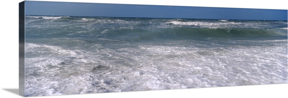 Waves break just of shore in this panoramic photograph of a Gulf Coast beach.