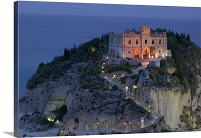 High angle view of a church lit up at dusk on a cliff, Santa Maria dell Isola, Tropea, Calabria, Italy
