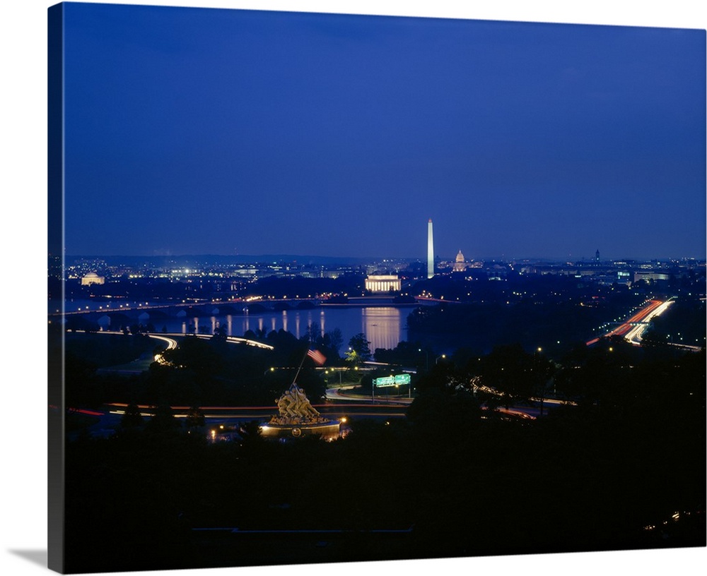 This large piece is a high angle photograph at night of Washington DC with many monuments lit up and in view.