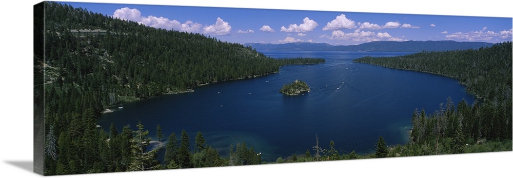 Big panoramic photo of Lake Tahoe, California (CA). The land surrounding the lake is covered with thick forest and boats a...